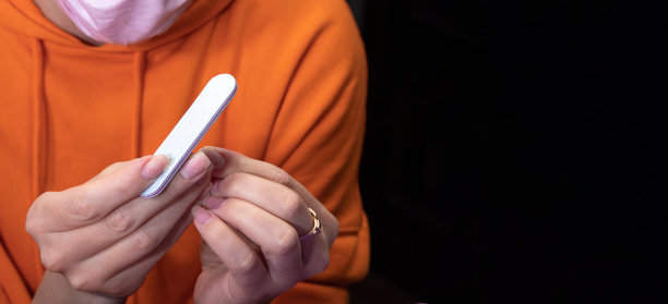 手里拿着小文件。特写镜头。自我修甲的过程。图片美容网站。有选择性的重点。图片下载