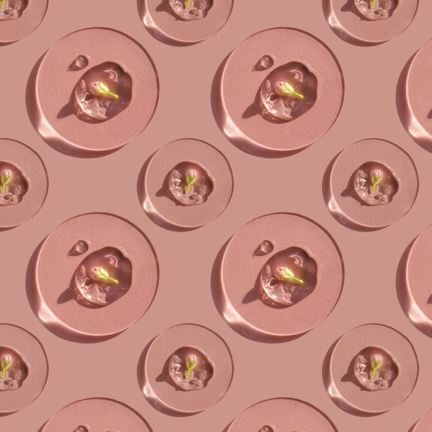 一滴化妆品凝胶，粉红色的背景上有一朵花。图片下载