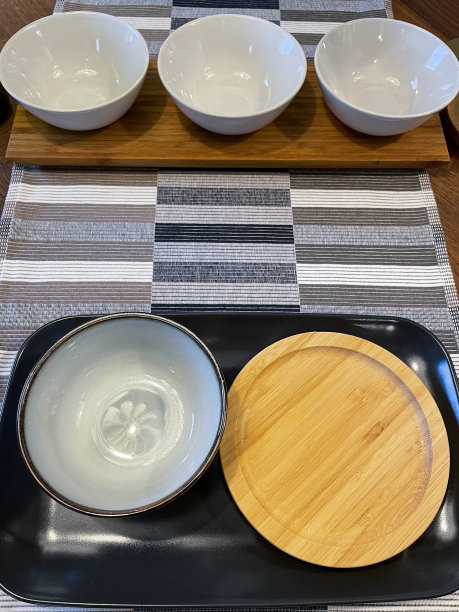 木质厨房餐桌的特写图像，由橡木制成，早餐/午餐/晚餐与白色盘子和盘子上的黑色托盘，编织的地方垫，高架视图图片下载