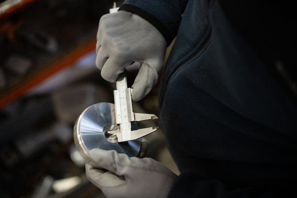 工厂工作是用卡尺测量机器零件图片下载