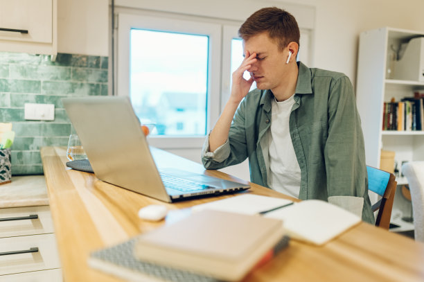 疲惫的人在家用笔记本电脑图片下载