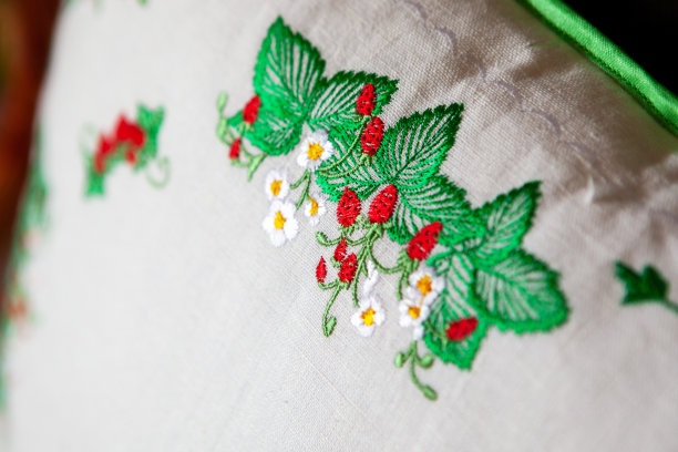 彩色的刺绣设计在野生草莓的形式，在一个白色的亚麻枕头，特写。图片下载