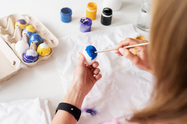 从头顶俯瞰，在厨房里给复活节彩蛋上色的女人图片下载
