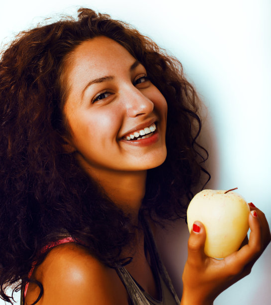 漂亮年轻的真少女吃苹果近面微笑，女人吃健康食品图片下载