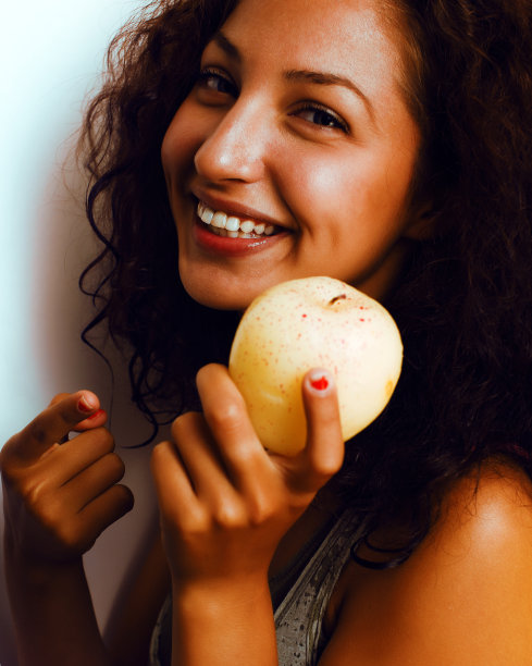 漂亮年轻的真少女吃苹果近面微笑，女人吃健康食品图片下载