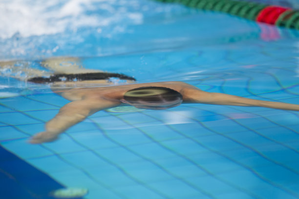 一个男人在泳池里游泳。图片下载