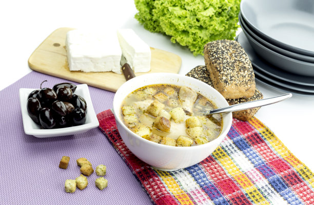 一张桌子上白色盘子里的鸡汤特写图片下载