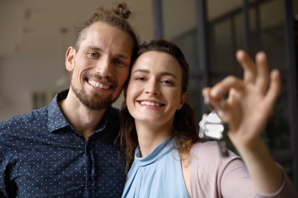 一对幸福的年轻夫妇，拿着相机的钥匙。图片下载