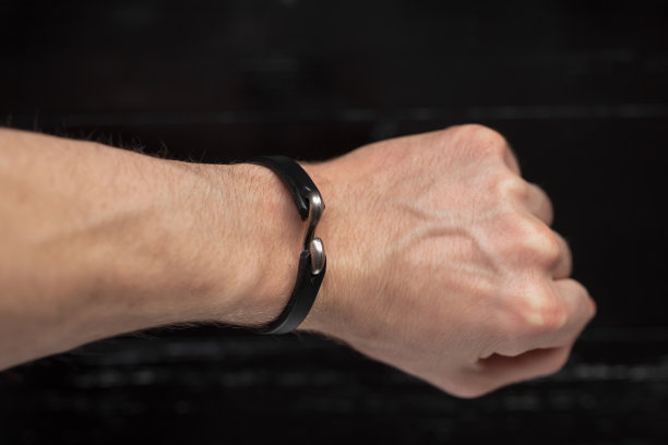 男性手上的黑色皮革手镯图片下载