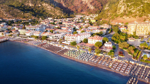 土耳其图伦克海滩的航拍照片。无人机拍摄到度假村里的日出。沙滩上一排排的雨伞和日光浴床。图片下载