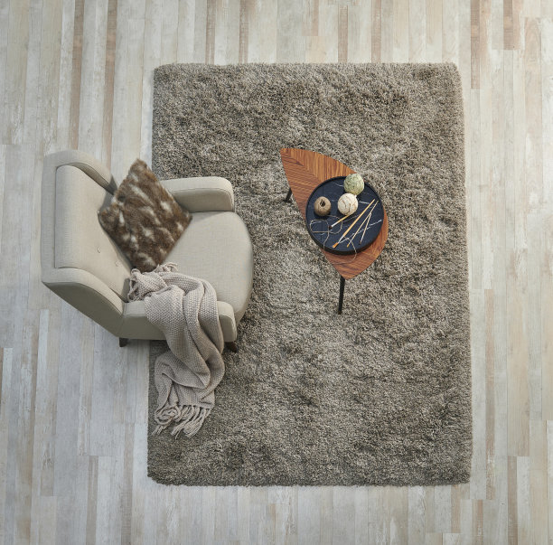 地毯向上，上面，上面的拼花，椅子中间的咖啡桌，家居装饰品，枕头和毯子风格。图片下载