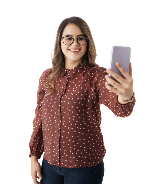 年轻女子拿着手机，微笑着自拍图片下载