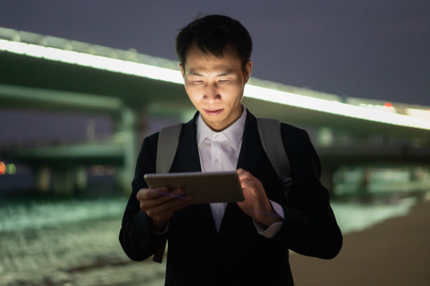 亚洲男子在海边用平板电脑查海图图片下载