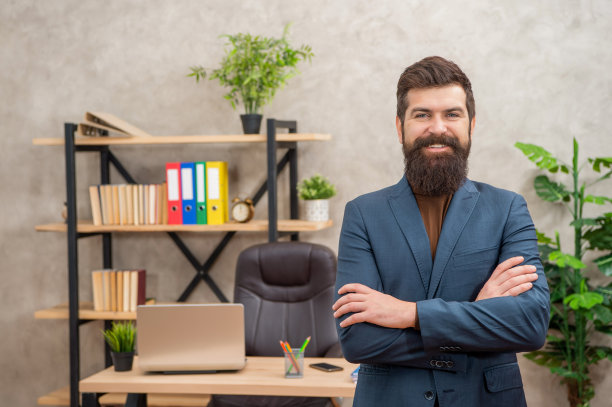 快乐的成熟企业家穿着夹克站在办公室里，穿着正装图片下载