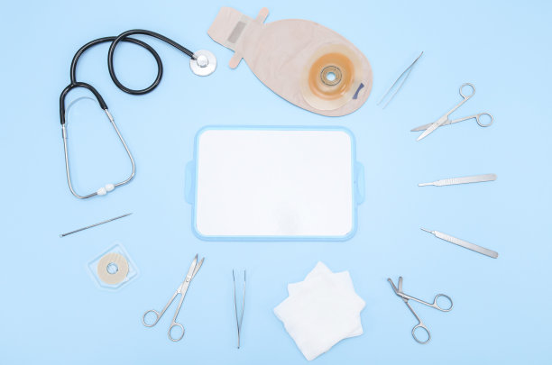 结肠造口袋，手术器械，听诊器和绷带放在一块蓝色的白板上图片下载