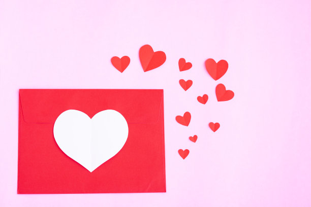 红信封，红色的心剪纸在粉红色的背景图片下载