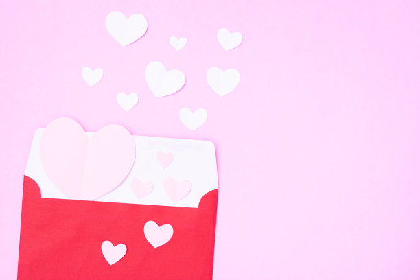 红信封，红色的心剪纸在粉红色的背景图片下载