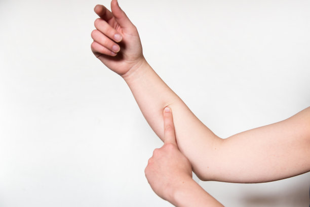 一个女人用手指按压她的前臂。图片下载