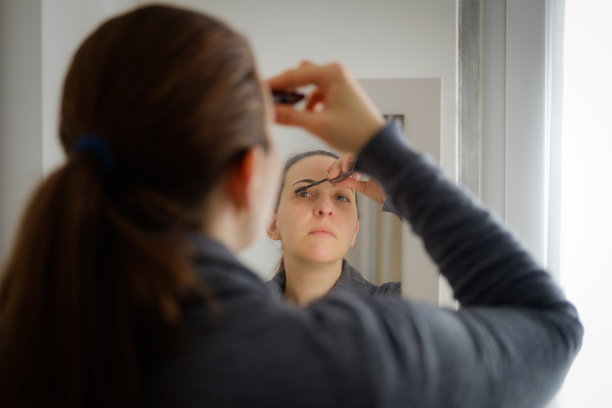女人把睫毛膏涂在镜子上图片下载
