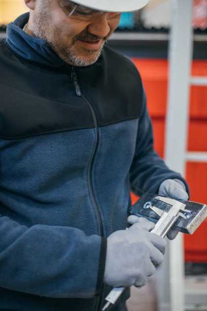 工厂工作是用卡尺测量机器零件图片下载