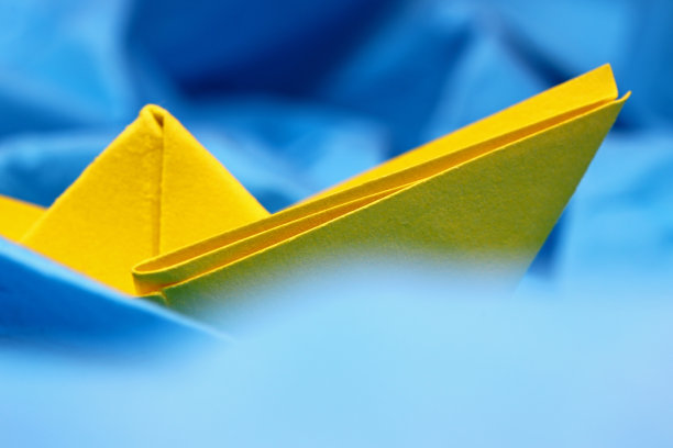 黄色的纸船在蓝色的纸上图片下载