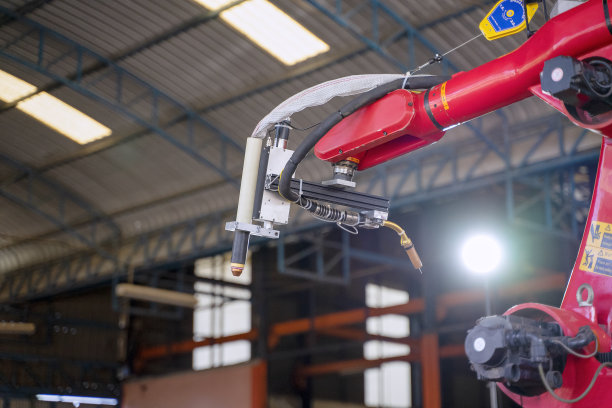 工人们在工厂里用机械手臂工作。图片下载