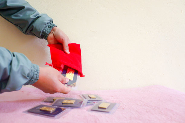 模糊不清的手商人数着粉红色桌子上的金条。图片下载