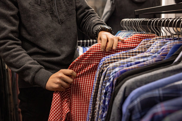 一个认不出来的白人顾客在精品店里挑选衬衫图片下载