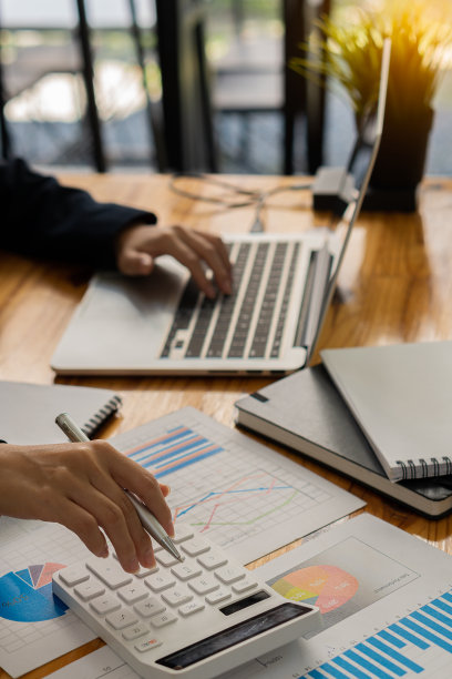 会计使用计算器和计算机，同时坚持企业会计的概念。预算和贷款手的人赚钱和计算费用在办公室垂直的图片图片下载