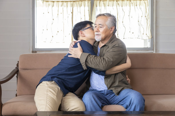 资深亚洲人拥抱和听坏消息，从他的儿子刚刚失去工作，回到家里寻求安慰和同情的父亲与复印空间图片下载