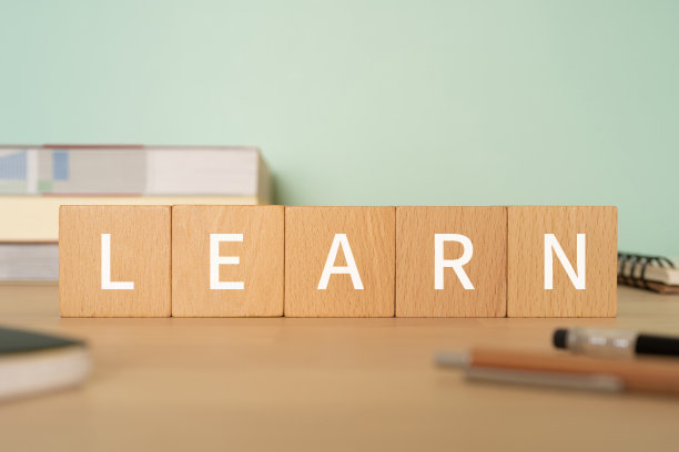 木块与“学习”的概念文本，笔，笔记本，和书。图片下载