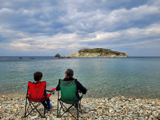 一个男人和他的儿子坐在沙滩上图片下载