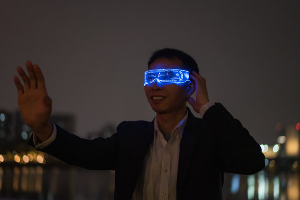 未来科技，男性白领在晚上戴着增强现实眼镜图片下载