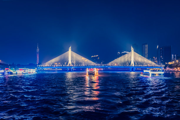 横跨珠江的吊桥，珠江上的游船，广州塔在远处图片下载