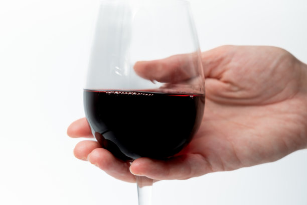 女人的手拿着一杯上了白的红酒，酒精中毒了图片下载