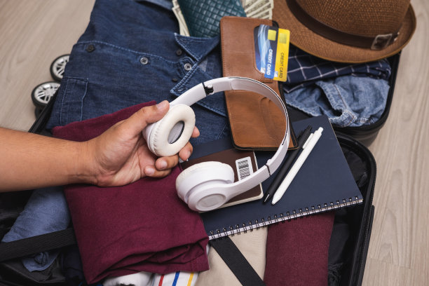 在旅途中收好钱包，现金预算和智能手机用于旅行。推车袋和旅行配件的背景。为游客支付的钱。美元钞票。图片下载