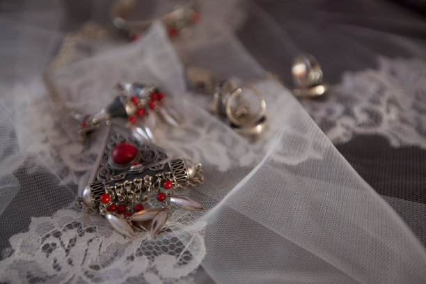 两枚金婚戒和白色背景上的玫瑰花。水平框中的图片。两枚结婚戒指和一张结婚请柬图片下载