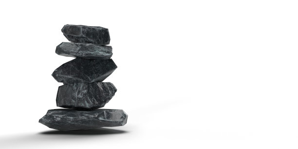 平衡的黑色花岗岩石头在白色背景与复制空间。图片下载