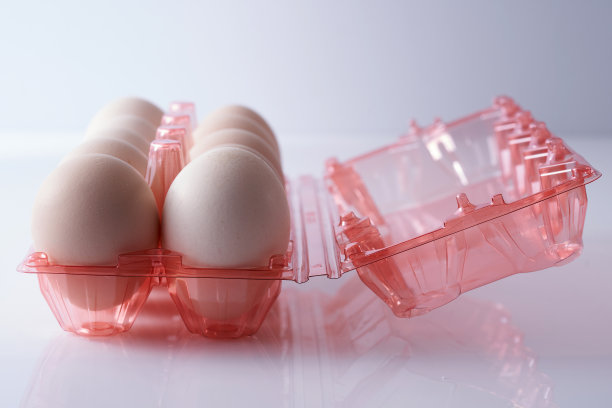 鸡蛋在透明的塑料盒在白色的背景图片下载