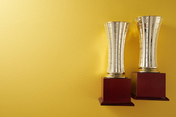 黄色背景下的金色奖杯图片下载