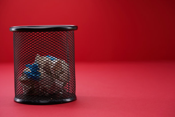 垃圾桶与碎纸的一面孤立在红色背景上图片下载
