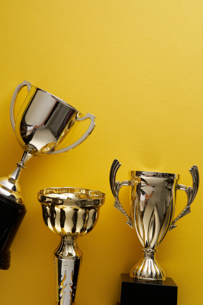 黄色背景下的金色奖杯图片下载