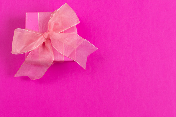 粉红色的礼盒与粉红色的蝴蝶结在粉红色的背景图片下载
