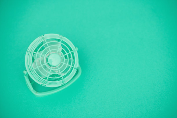 小蓝绿色书桌扇在蓝绿色背景与复制空间图片下载