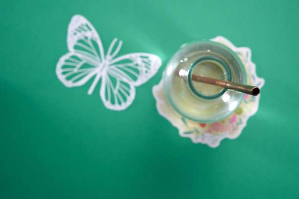 选择性聚焦在金属吸管与玻璃罐在绿色背景下图片下载