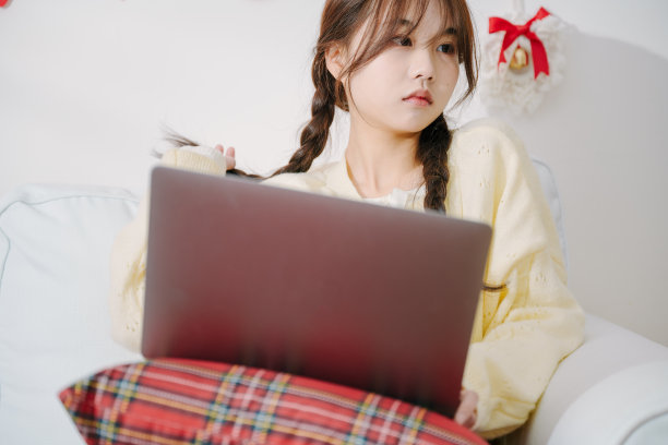 亚洲年轻女性周末在床上用电脑工作图片下载