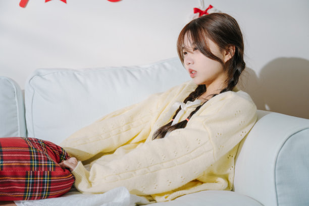 快乐的亚洲年轻女性周末躺在沙发上休息图片下载