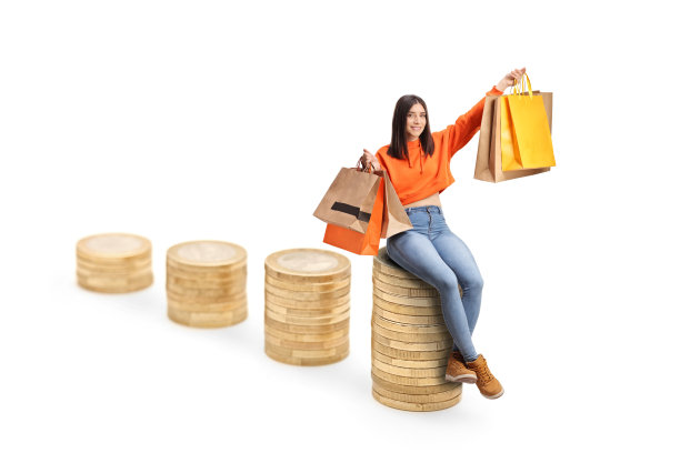 快乐的年轻女性坐在硬币上面，手里拿着购物袋图片下载