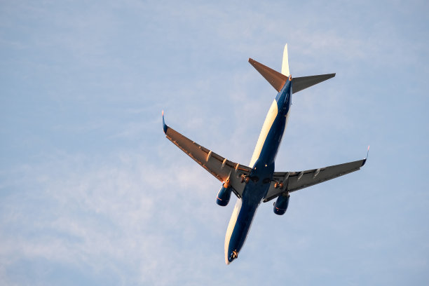 一架飞机在天空中飞行，云朵为背景图片下载