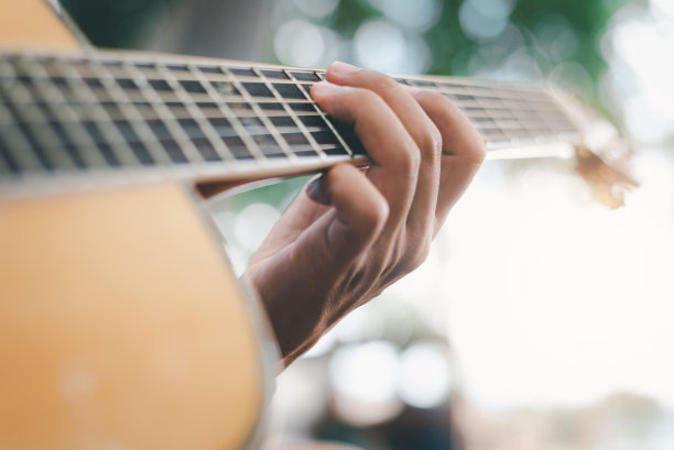 柔和的焦点，男人演奏经典的原声吉他图片下载
